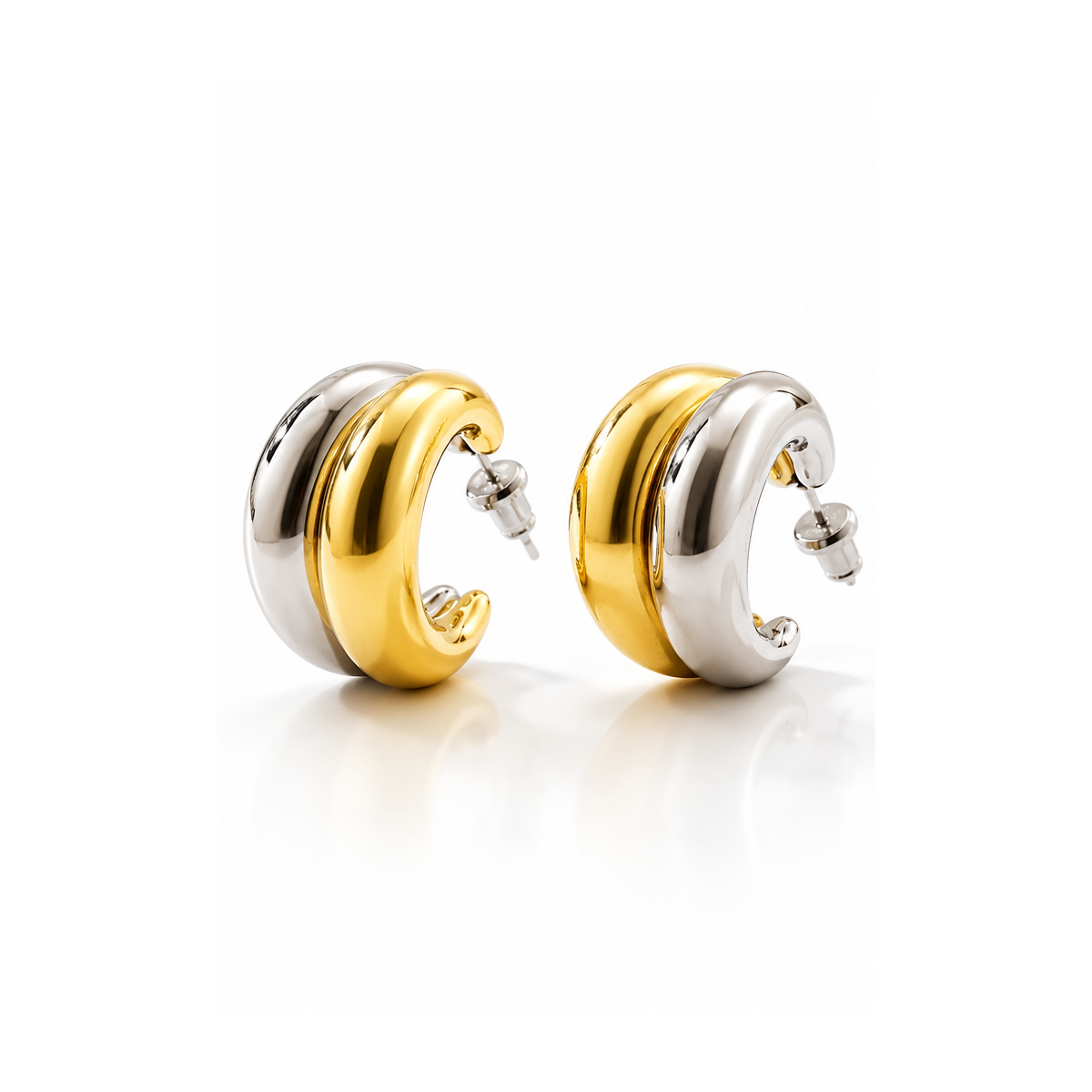Two-tone sculptural gold and silver hoop earrings on white background